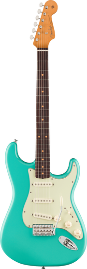 Turquoise electric guitar on a green background